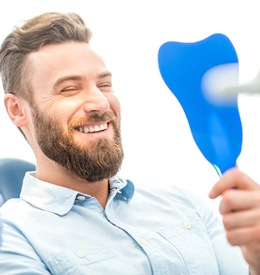 Male dental patient checking his smile after cosmetic gum augmentation