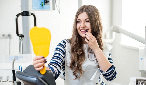 woman holding dental mirror
