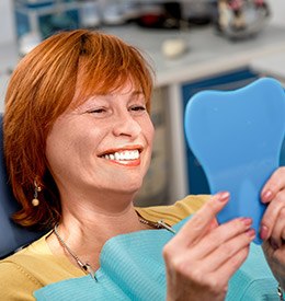 Woman looking at her smile in the mirror