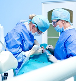 Two dentists performing dental work on a patient