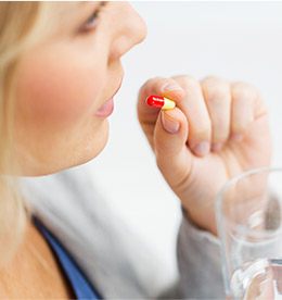 Woman taking an antibiotic pill