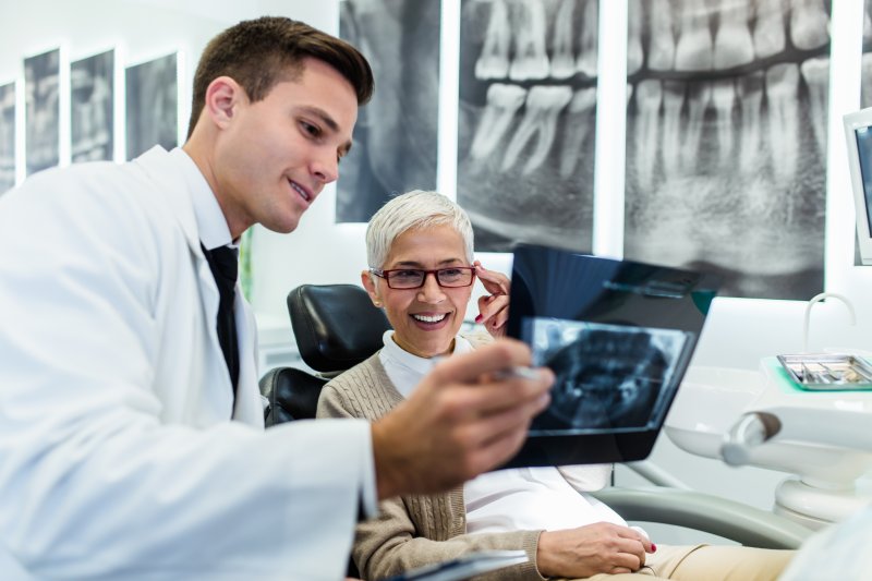 A woman looking at an X-ray with a dentist.