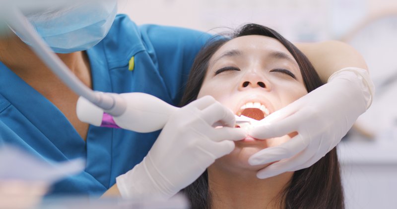 a young woman having her teeth cleaned while at the dentist’s office